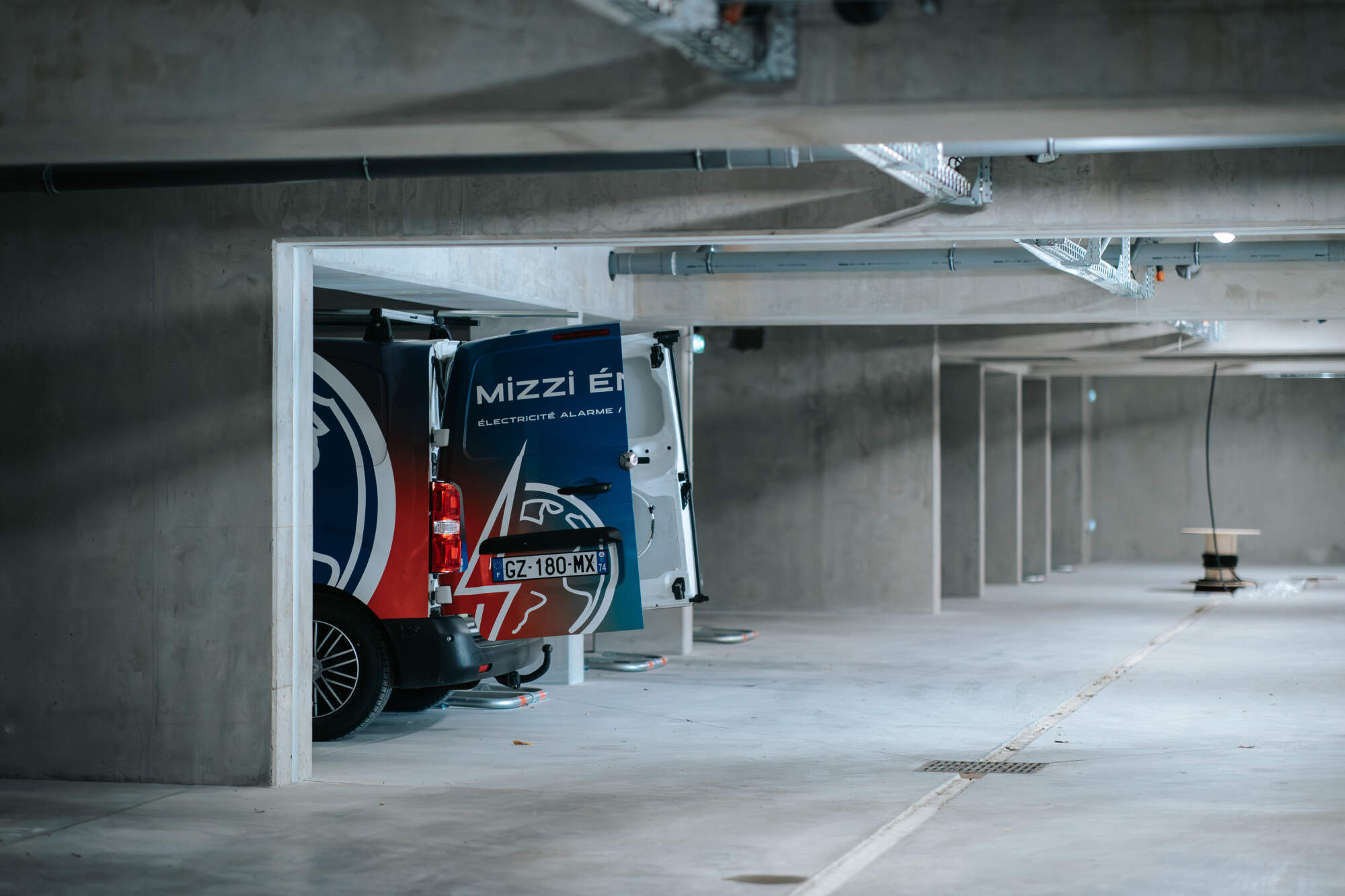 PHOTO D'UN VÉHICULE DE L'ENTREPRISE MIZZI ÉNERGIE EN INTERVENTION DANS UN GARAGE DE COPROPRIÉTÉ
