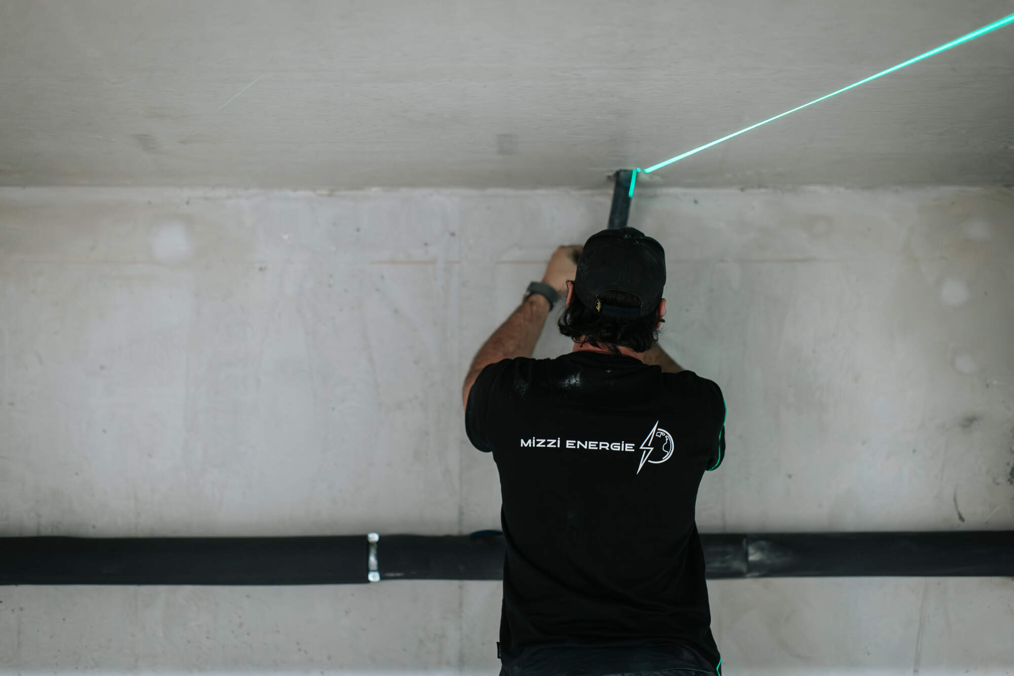 PHOTO D'UN ÉLECTRICIEN ENTRAIN D'INSTALLER UN SYSTÈME D'ÉLECTRICITÉ GÉNÉRALE - MIZZI ÉNERGIE