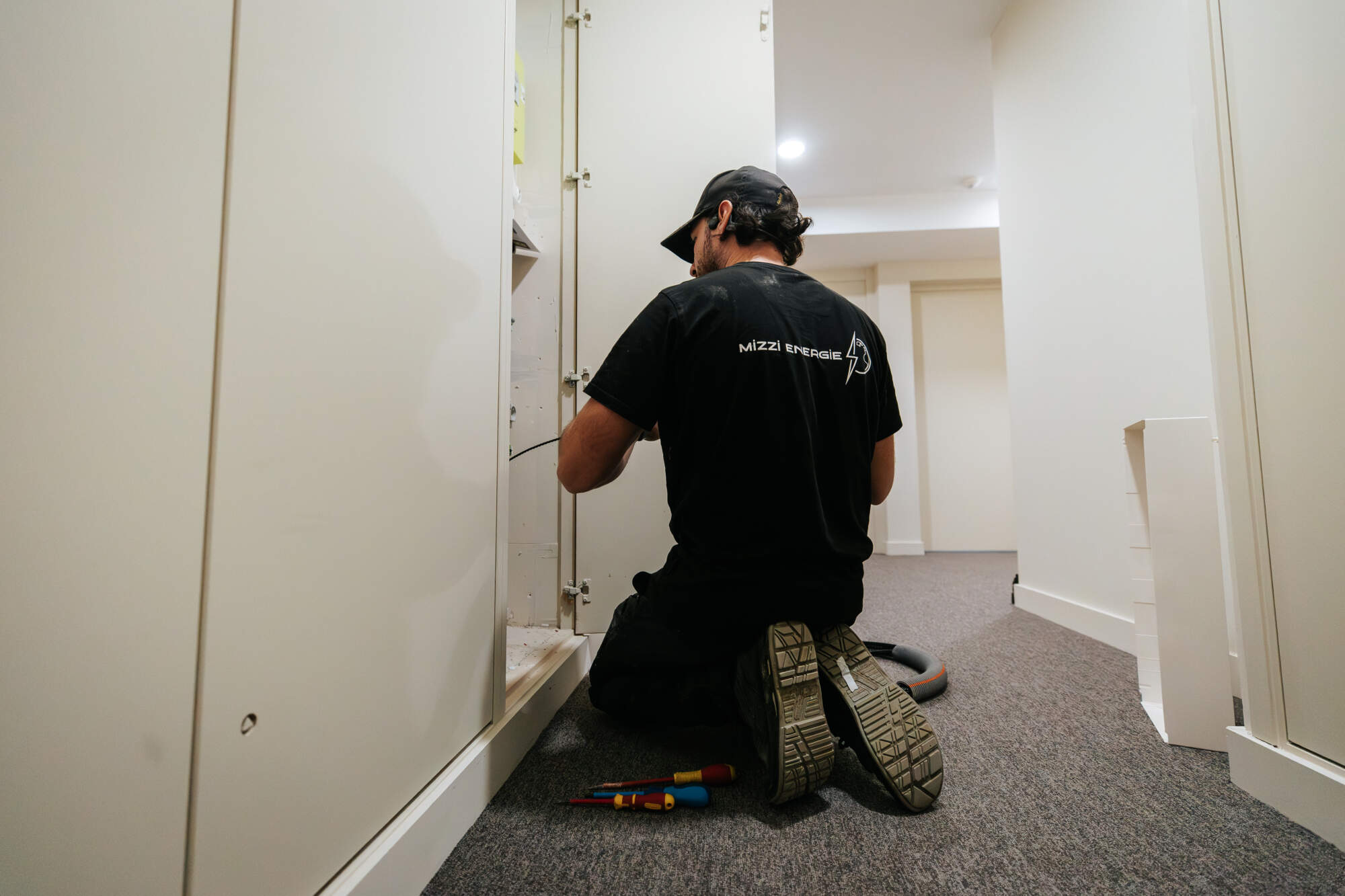 PHOTO D'UN ÉLECTRICIEN ENTRAIN DE RÉPARER UN SYSTÈME CENTRAL D'ÉLECTRICITÉ GÉNÉRALE DANS UN IMMEUBLE